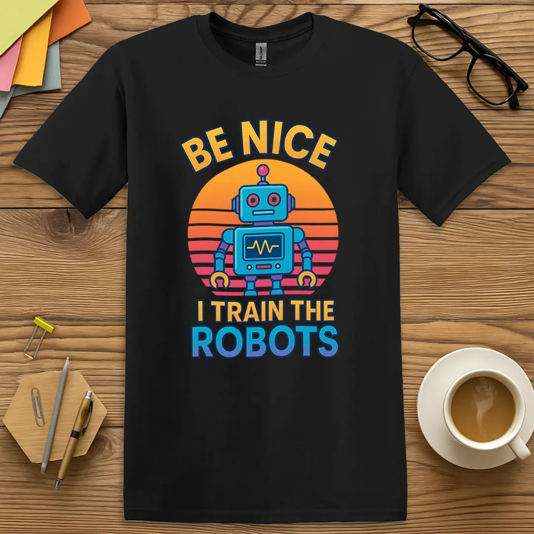 Black Color T-Shirt with "Be Nice I Train The Robots" design showing contrast-heavy style with futuristic flair and AI classroom vibes.