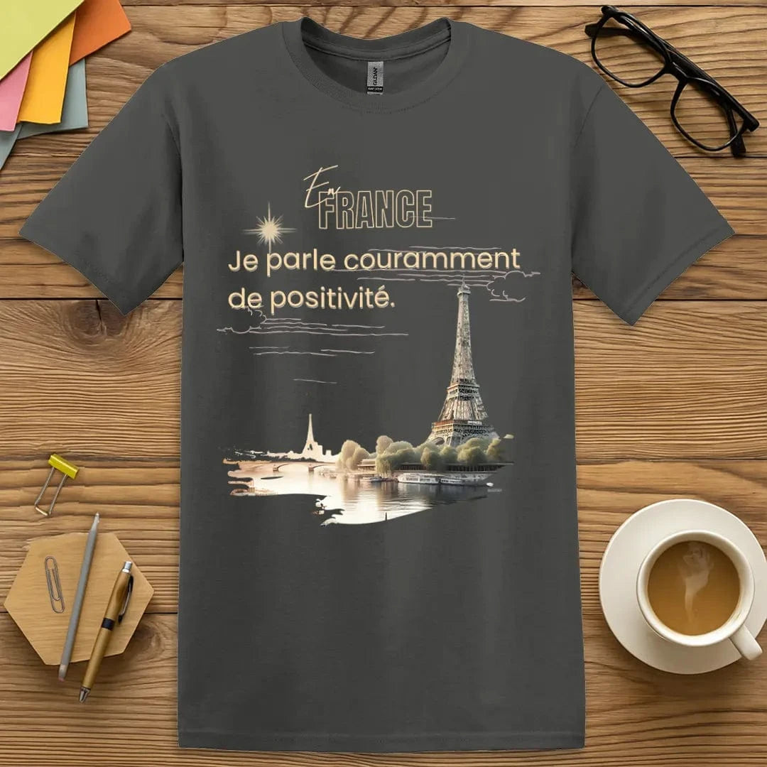 Charcoal T-shirt with “En France, je parle couramment de positivité” design featuring chic sarcasm and teacher pride