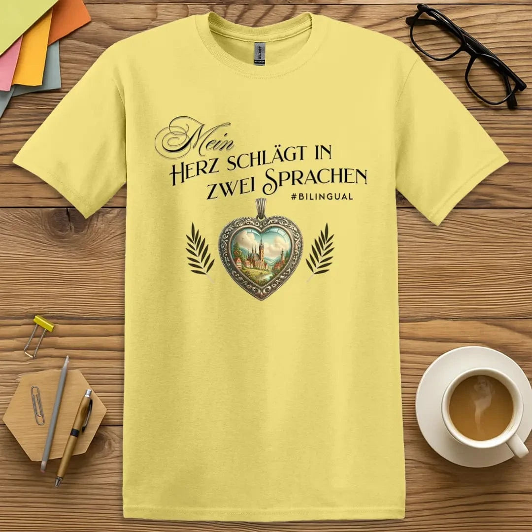 Cornsilk T-shirt with “Mein Herz schlägt in zwei Sprachen” design featuring ornate heart and countryside for bilingual German language lovers