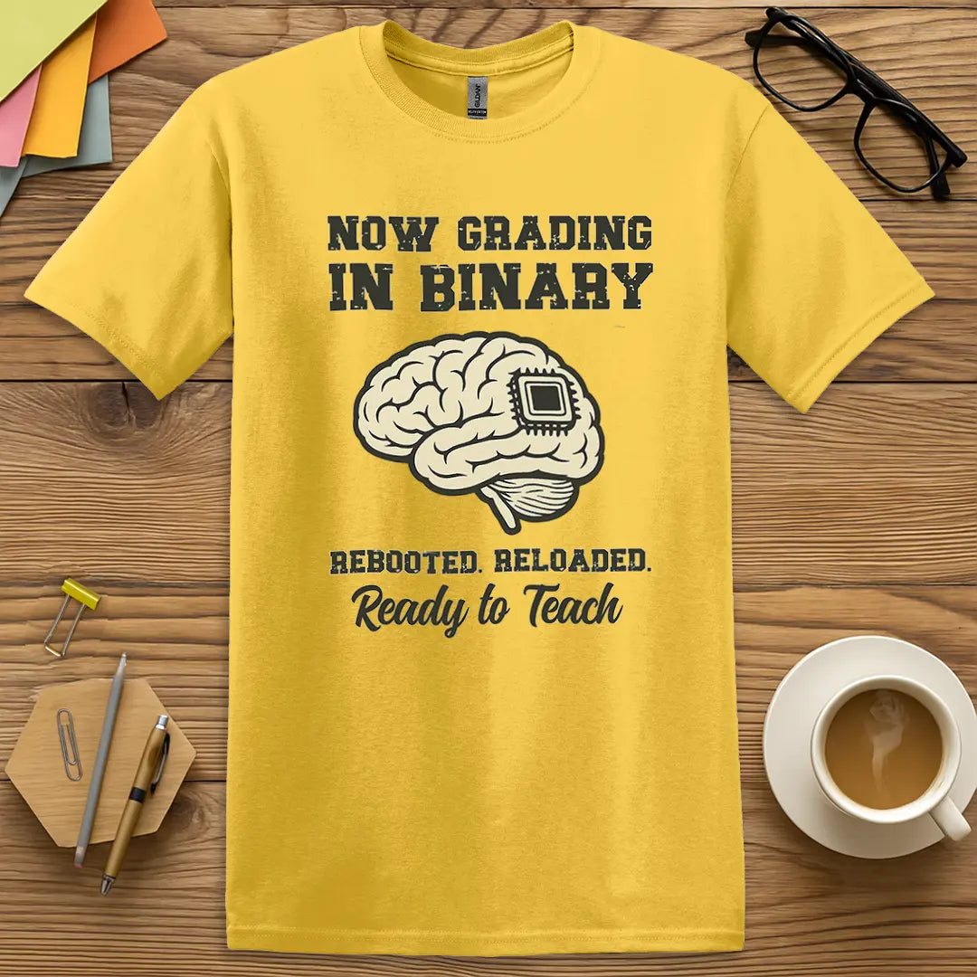 Daisy Color T-shirt with "Now Grading in Binary – Rebooted. Reloaded. Ready to Teach" design combining bright energy with geeked-out grading humor.