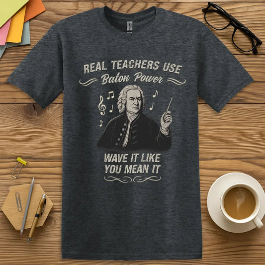 Dark Heather Color T-shirt with "Real Teachers Use Baton Power - Wave It Like You Mean It" design showing historical maestro and clever music pun.