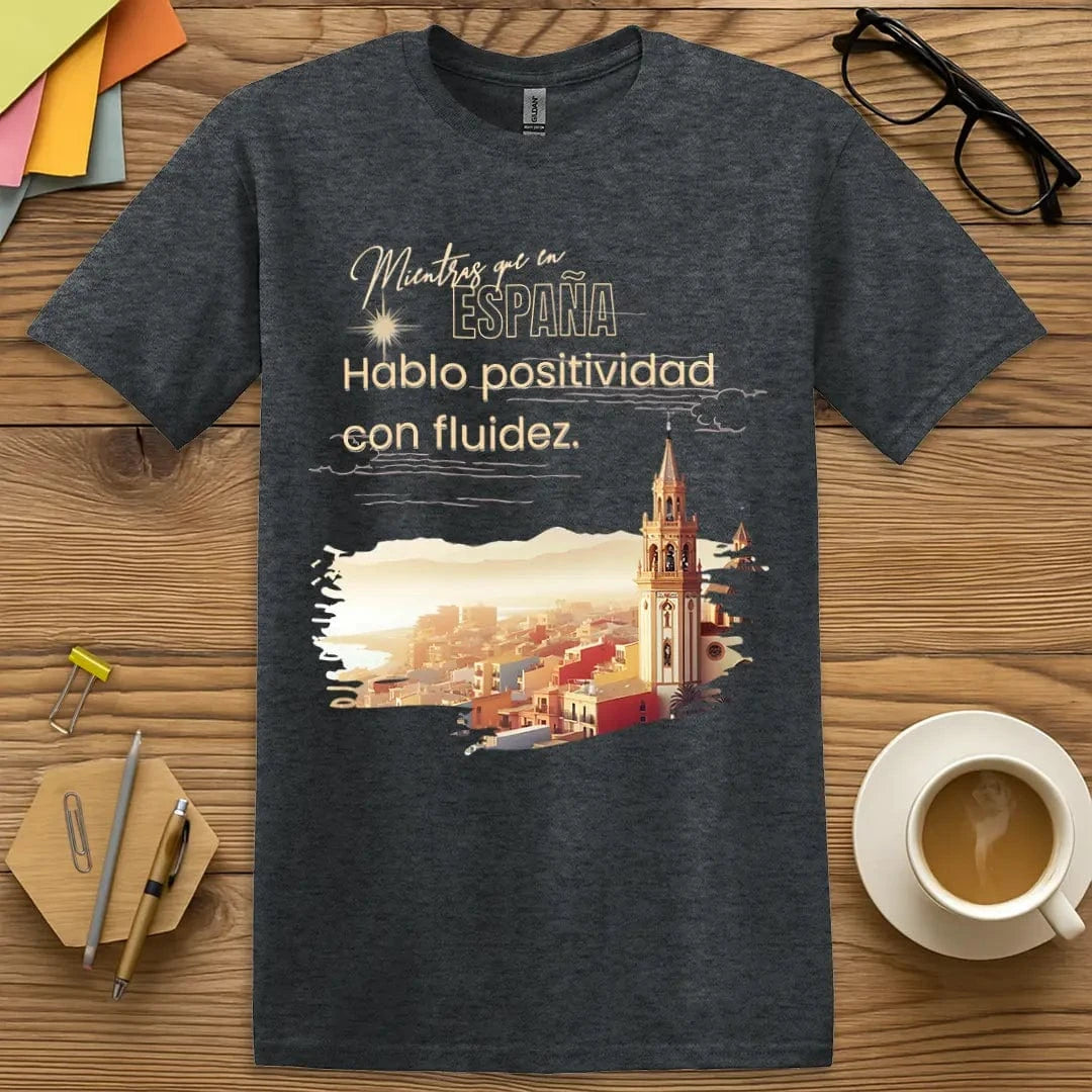 Dark Heather T-shirt with “Mientras que en España, Hablo positivo con fluidez” design featuring subtle color and smart language pun style