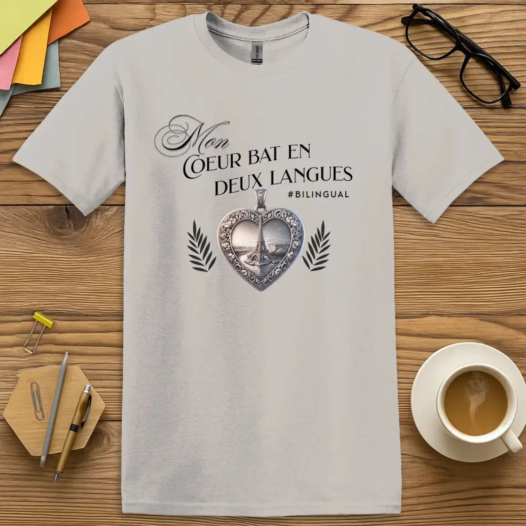 Ice Grey T-shirt with “Mon cœur bat en deux langues” design featuring an ornate heart pendant and Eiffel Tower – sleek neutral for the chic Francophile