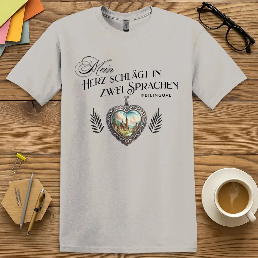 Ice Grey T-shirt with “Mein Herz schlägt in zwei Sprachen” design featuring ornate heart and countryside for bilingual German language lovers