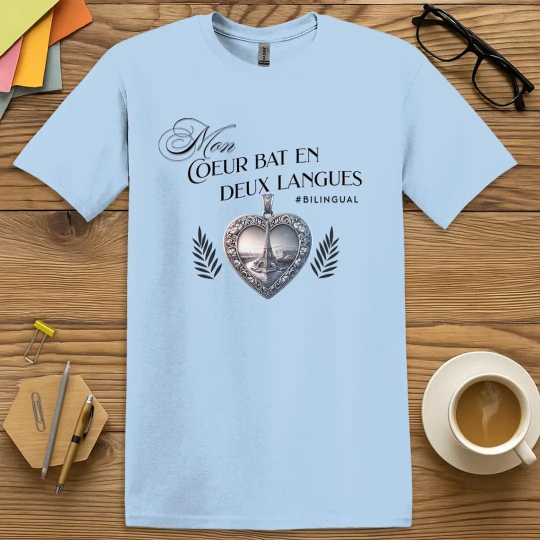 Light Blue T-shirt with “Mon cœur bat en deux langues” design featuring an ornate heart pendant and Eiffel Tower – cool and calming shirt for language enthusiasts