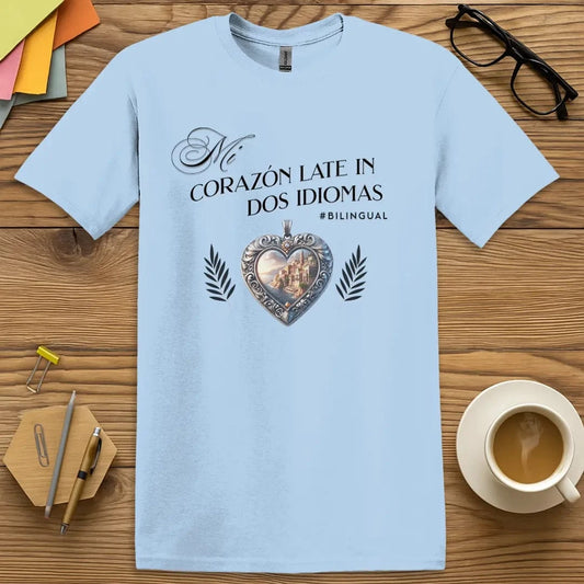 Light Blue T-shirt with "Mi Corazón Late en Dos Idiomas" design featuring Spanish coastal heart pendant and bilingual pride.