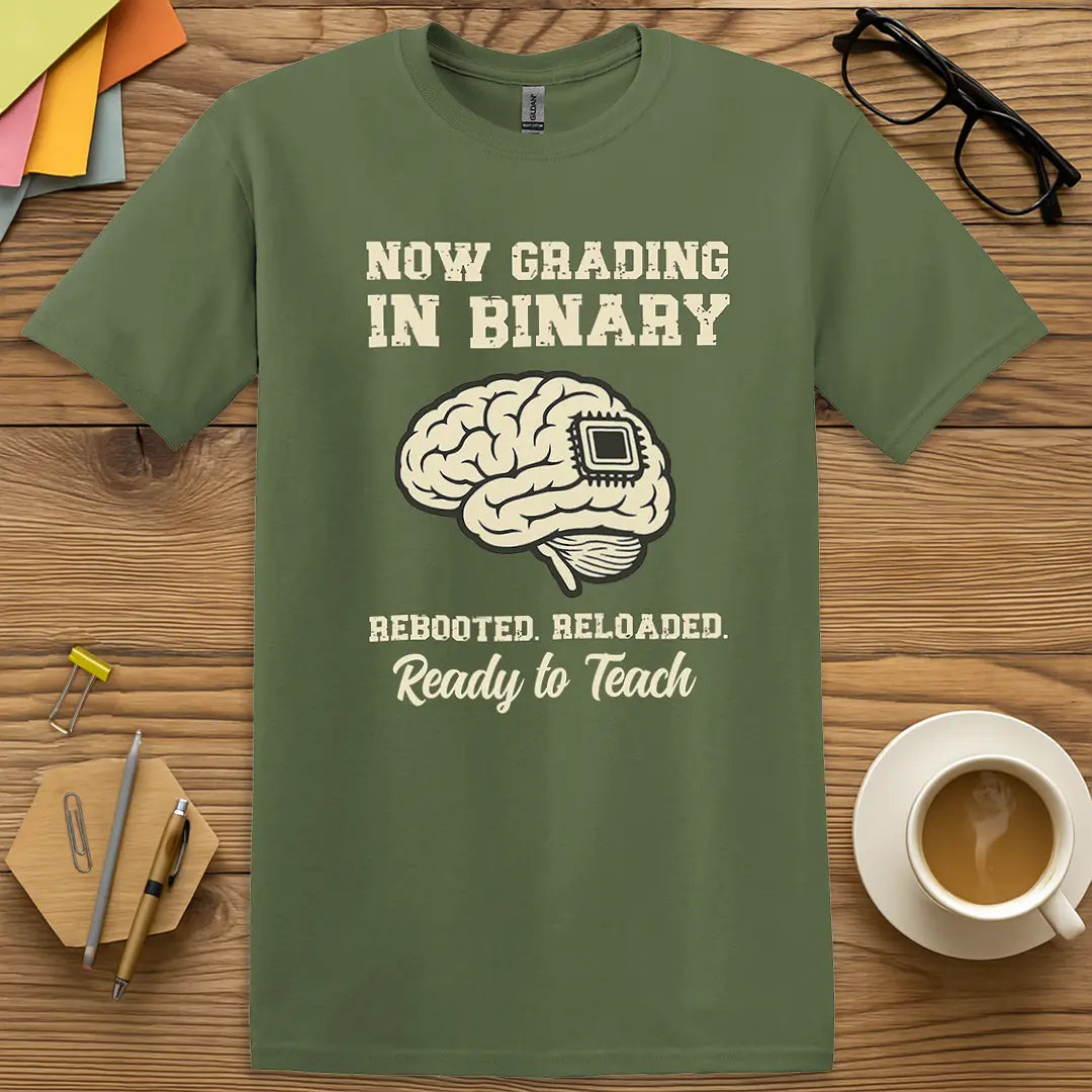Military Green Color T-shirt with "Now Grading in Binary – Rebooted. Reloaded. Ready to Teach" design evoking classroom tech wit and binary attitude.