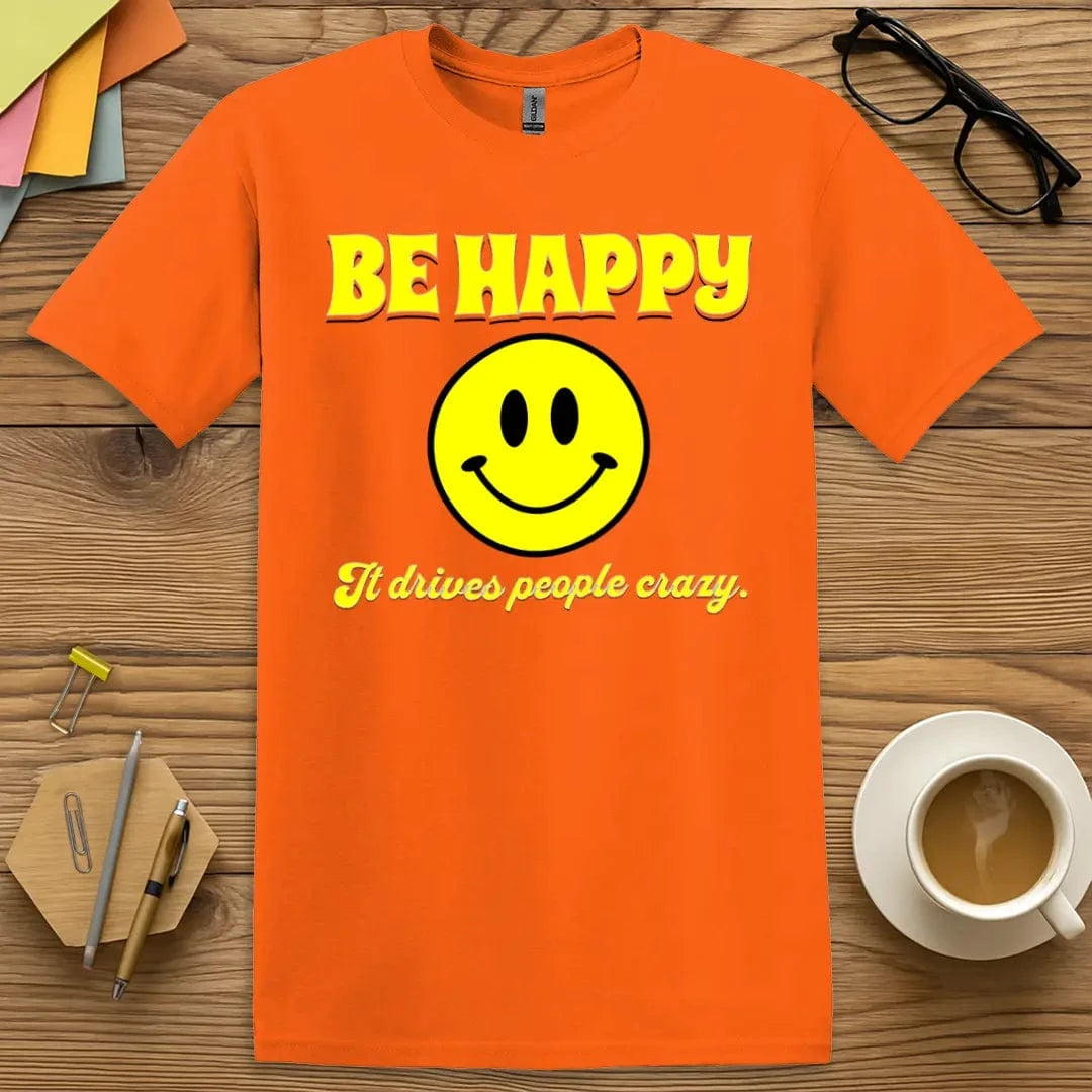 Orange T-shirt with "Be Happy It Drives People Crazy" design blending bold retro style with cheeky positivity vibe.