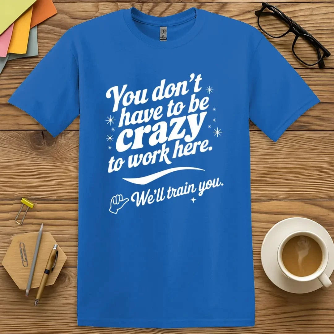 Royal T-shirt with "You Don’t Have to Be Crazy… We’ll Train You" design featuring vibrant classroom chaos vibe.