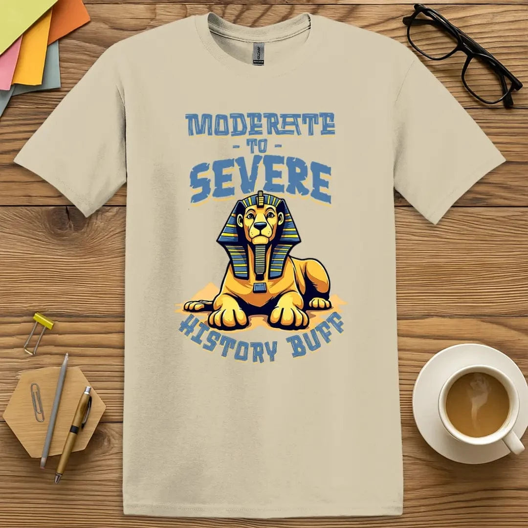 Sand Color T-Shirt with "Moderate to Severe History Buff" design featuring a cartoon sphinx-lion combo in bold blue and gold, perfect for sarcastic educators and ancient history lovers.