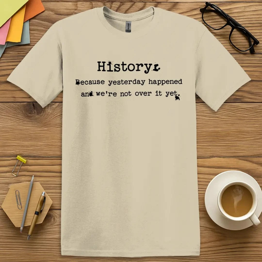 Sand T-shirt with "Not Over It Yet" design featuring muted classroom aesthetic and context-loaded messaging.