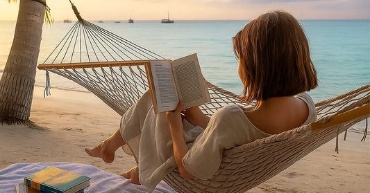 eacher relaxing in a hammock on the beach while reading a book during summer break, symbolizing a digital detox before the new school year.