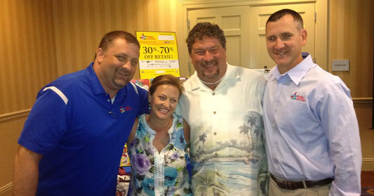 Four Books Are Fun regional representatives pose together at an award ceremony in 2013, celebrating their recognition as Regional Reps of the Year. Everyone is smiling, with one rep wearing a tropical shirt that totally stole the show.