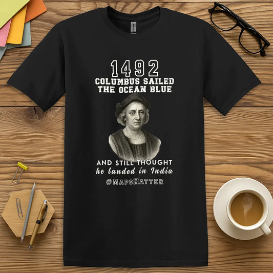 Black Color T-Shirt with "1492 Columbus Sailed the Ocean Blue and Still Thought He Landed in India #MapsMatter" design featuring vintage portrait and historical humor.
