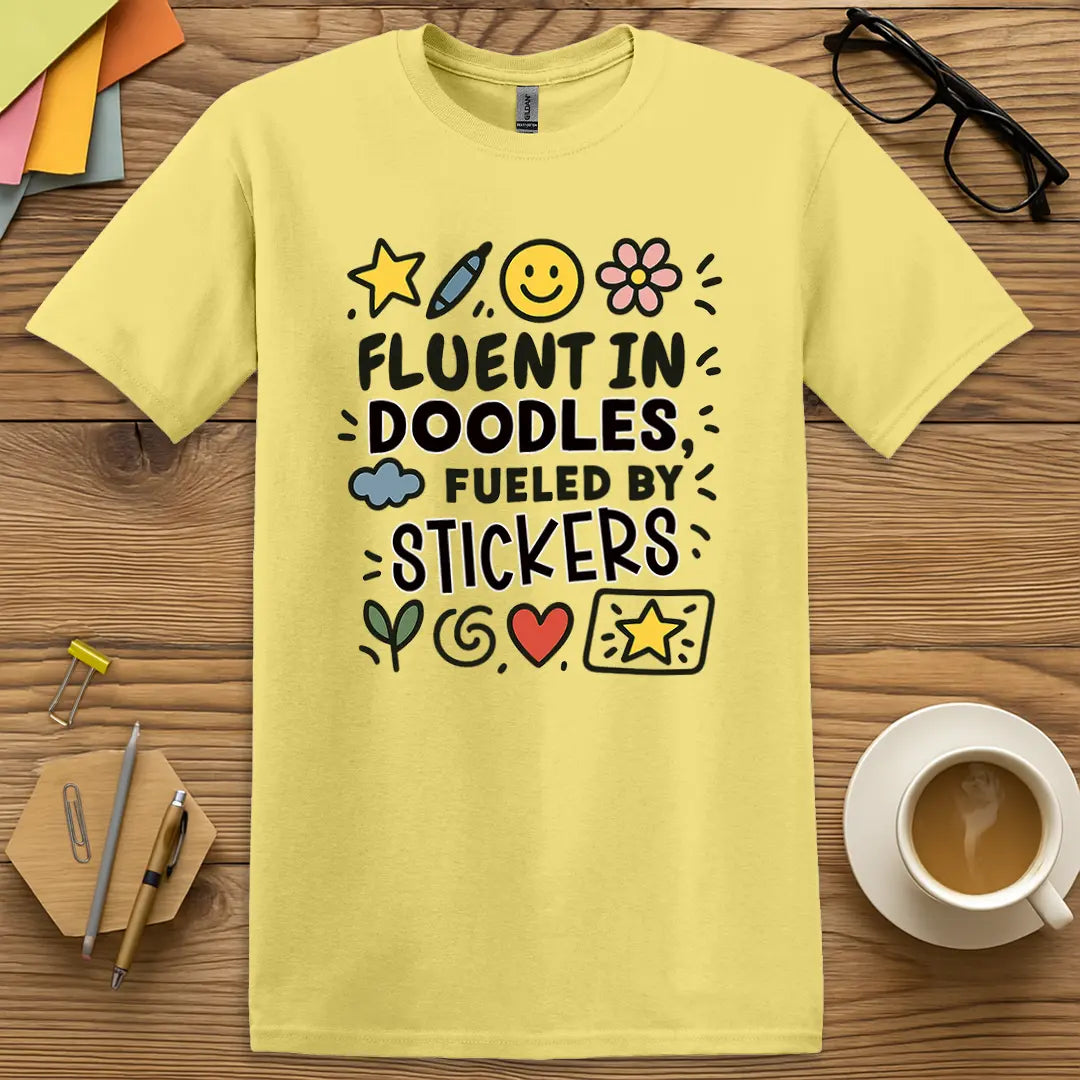 Cornsilk Color T-shirt with "Fluent in Doodles, Fueled by Stickers" design for soft aesthetic teachers and sticker-powered flair.