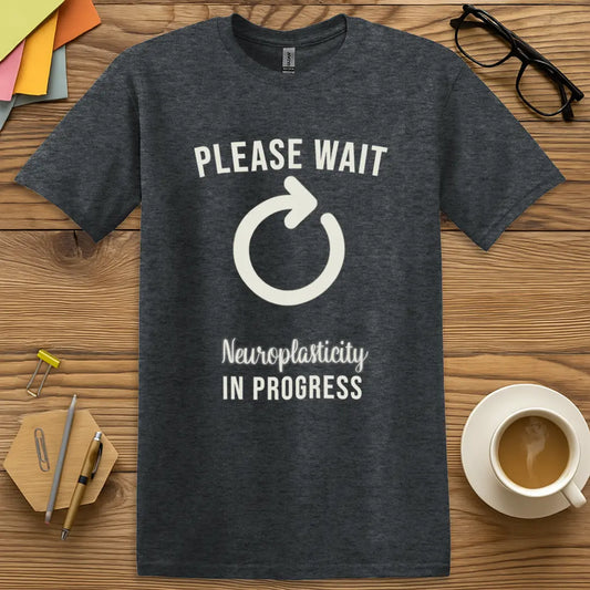 Dark Heather Color T-Shirt with "Please Wait Neuroplasticity In Progress" design featuring a bold loading symbol and science teacher humor.