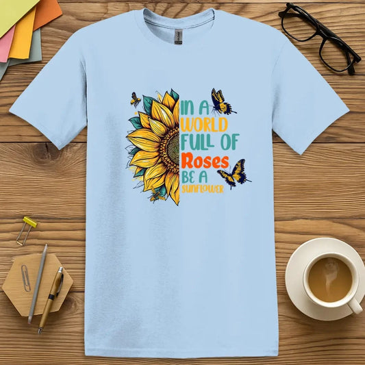 Light Blue Color T-shirt with "In a world full of roses, be a sunflower" design featuring bright sunflower, butterflies, and bold multicolor text.