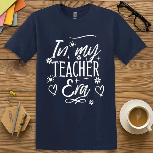 Navy T-shirt with “In My Teacher Era” design featuring whimsical flowers, hearts, and sparkles in a playful, celebratory style  