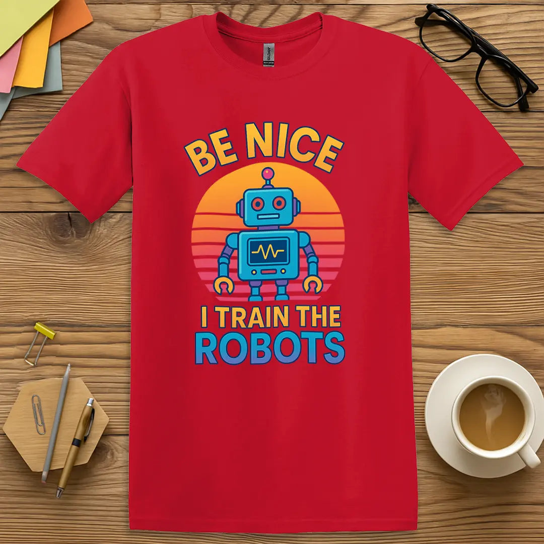 Red Color T-Shirt with "Be Nice I Train The Robots" design featuring vibrant sunset colors and playful STEM educator sarcasm.